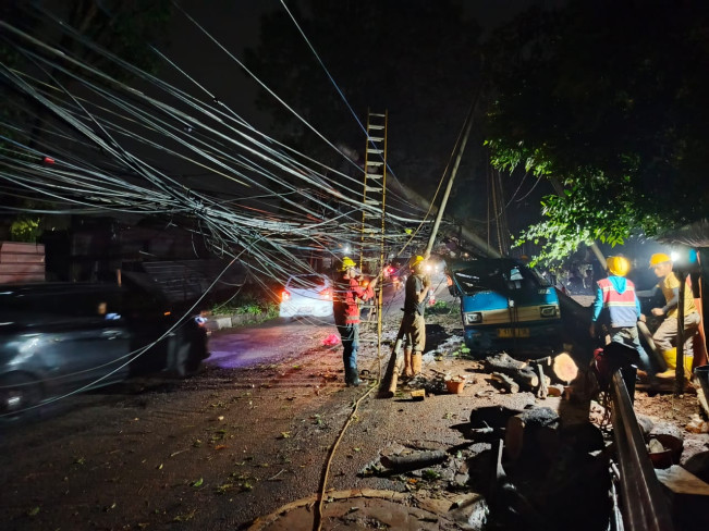 Sebuah angkot tertimpa tiang listrik akibat pohon tumbang saat hujan deras disertai angin kencang di Pondok Labu, Depok. (FTNews.co.id / Madinah)